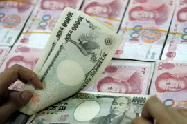 Đồng 10.000 yen Nhật (phía trên) và đồng 100 Nhân dân tệ của Trung Quốc (phía dưới) tại ngân hàng ở Hoài Bắc, tỉnh An Huy, Trung Quốc. (Ảnh: AFP/ TTXVN)