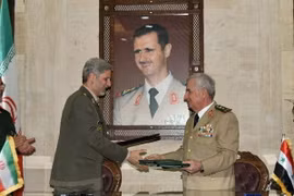 Bộ trưởng Quốc phòng Syria Abdullah Ayoub (phải) trao đổi văn kiện hợp tác với Bộ trưởng Quốc phòng Iran Amir Hatami (trái) đang ở thăm Damascus ngày 26/8. (Ảnh: AFP/TTXVN)