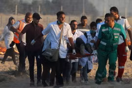 Chuyển người biểu tình Palestine bị thương tại khu vực biên giới Gaza- Israel ngày 3/8. (Ảnh: AFP/TTXVN)
