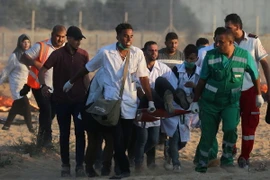 Chuyển người biểu tình Palestine bị thương tại khu vực biên giới Gaza- Israel ngày 3/8. (Ảnh: AFP/TTXVN)