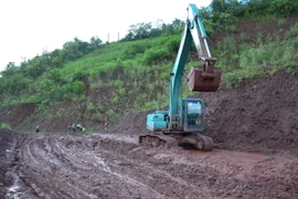 Đơn vị quản lý tuyến Quốc lộ 4H dọn sạch bùn nhão trên nền đường, đảm bảo tốt nhất cho các phương tiện giao thông qua lại. (Ảnh: Văn Dũng/TTXVN)