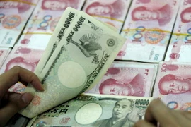 Đồng 10.000 yen Nhật (phía trên) và đồng 100 Nhân dân tệ của Trung Quốc (phía dưới) tại ngân hàng ở Hoài Bắc, tỉnh An Huy, Trung Quốc. (Ảnh: AFP/ TTXVN)