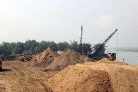 Một bến cát trái phép hoạt động rầm rộ dưới chân cầu đường sắt Yên Xuân, huyện Hưng Nguyên, Nghệ An. (Ảnh: Tá Chuyên/TTXVN)
