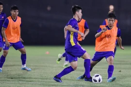 Văn Đức (áo cam) tranh bóng với Duy Mạnh (trái) tại buổi tập chiều 21/8. (Ảnh: Hoàng Linh/TTXVN)