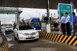 Một trong những phương tiện đầu tiên lưu thông qua Trạm BOT Quảng Trị thu phí tự động. (Ảnh: Nguyên Lý/TTXVN)