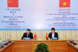 Ông Trần Vĩnh Tuyến và ông Tang Liangzhi ký Biên bản thỏa thuận thiết lập quan hệ thành phố hữu nghị. (Ảnh: Xuân Khu/TTXVN)