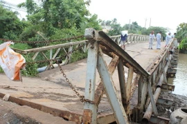 Mố cầu bị sập, đoạn ống cấp nước bị gãy khiến cho gần 1.000 hộ dân không có nước sinh hoạt. (Ảnh: Huỳnh Phúc Hậu/TTXVN)