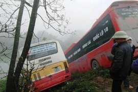 Hiện trường 2 chiếc ôtô lao xuống bờ sông. (Ảnh: Ninh Đức Phương/TTXVN)