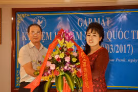 Tham tán Nguyễn Mạnh Cường tặng hoa chúc mừng đại diện Hội Phụ nữ Việt Nam tại Campuchia tại buổi gặp mặt. (Ảnh: Chanh Đa/TTXVN)