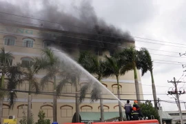 Lực lượng Cảnh sát PCCC Cần Thơ nỗ lực phun nước để dập lửa. (Ảnh: Thanh Liêm/TTXVN)