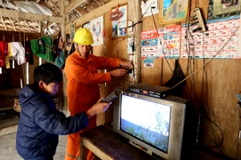 Công nhân Công ty Điện lực Thái Nguyên hướng dẫn người dân sử dụng điện an toàn. (Ảnh: Ngọc Hà/TTXVN)