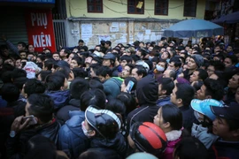 Chen lấn xô đẩy để lấy số thứ tự tiêm văcxin cho con mình. (Ảnh: Minh Sơn/Vietnam+)