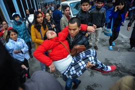 Một người phụ nữ đã ngất xỉu, phải đưa đi cấp cứu. (Ảnh: Minh Sơn/Vietnam+)