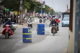 Những chiếc thùng phuy thình lình xuất hiện tại tuyến đường từ Nhổn đến Cầu Diễn làm người tham gia giao thông bất ngờ. (Ảnh: Minh Sơn/Vietnam+)