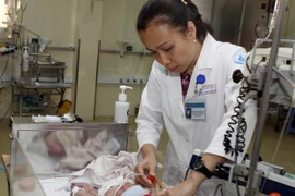 Bác sỹ Phạm Thị Thanh Tâm, Trưởng khoa Hồi sức Sơ sinh, Bệnh viện Nhi đồng 1 Thành phố Hồ Chí Minh thăm khám cho bệnh nhi. (Ảnh: Phương Vy/TTXVN)