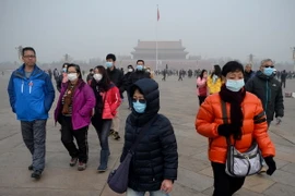 Người dân đeo khẩu tranh phòng tránh khói bụi tại Bắc Kinh. (Nguồn: AFP/TTXVN)