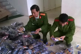Kiểm đếm số hàng hóa vận chuyển trái phép bị thu giữ. (Ảnh: Trịnh Duy Hưng/TTXVN)