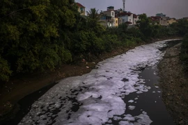 Một đoạn đầy rác thải và bọt hóa chất phủ đầy mặt sông Nhuệ, đoạn qua phường Cầu Diễn, quận Nam Từ Liêm, Hà Nội. (Ảnh: Trọng Đạt/TTXVN)