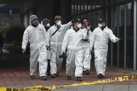 Cảnh sát và nhân viên cứu hỏa điều tra tại hiện trường vụ hỏa hoạn. (Nguồn: EPA/TTXVN)