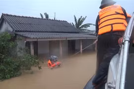 Bộ đội Biên phòng tỉnh Quảng Trị di dời những người dân bị mắc kẹt trong lũ đến nơi an toàn. (Ảnh: Hồ Cầu/TTXVN)