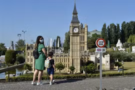 Du khách chụp ảnh gần công viên châu Âu thu nhỏ ở Brussels, Bỉ. (Ảnh: AFP/TTXVN)