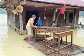 Lực lượng biên phòng cùng cán bộ giáo viên và nhân dân tại xã Trường Sơn, huyện Quảng Ninh, Quảng Bình di dời bàn ghế, vật dụng dạy học lên nơi cao ráo. (Ảnh: Võ Dung/TTXVN)