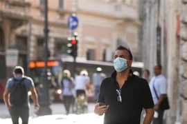 Người dân đeo khẩu trang phòng lây nhiễm COVID-19 tại Rome, Italy. (Ảnh: THX/TTXVN)