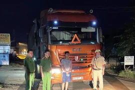 Tài xế Nguyễn Văn Tú và xe tải chở phế liệu nhập lậu bị lực lượng chức năng bắt giữ. (Ảnh Lê Đức Hoảnh/TTXVN)