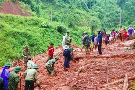 Bộ đội Biên phòng Đồn Cà Roòng, Quảng Bình cùng các lực lượng chức năng xã Thượng Trạch, huyện Bố Trạch tham gia sửa chữa, san lấp, thông một số tuyến đường. (Ảnh: Võ Dung/TTXVN)