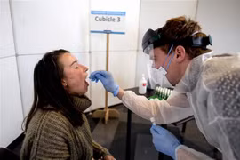 Nhân viên y tế lấy mẫu xét nghiệm COVID-19 tại Leuven, Bỉ. (Ảnh: AFP/TTXVN)