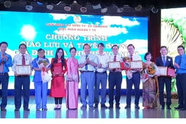 Lãnh đạo Liên đoàn Lao động Thành phố Hồ Chí Minh cùng Công đoàn ngành y tế Thành phố trao biểu trưng tuyên dương gia đình ba thế hệ ngành y năm 2020. (Ảnh: Thanh Vũ/TTXVN)