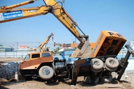 Xe cẩu vướng dây điện lật nhào, chèn người đi đường