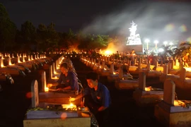 Gắn hoa cho liệt sỹ ở Nghĩa trang liệt sỹ quốc gia đường 9