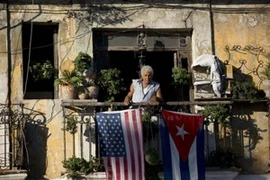 Một người dân treo cờ Mỹ và Cuba ở ban công của một ngôi nhà tại La Habana của Cuba. (Nguồn: AP)