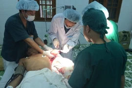 Các bác sỹ Bệnh viện Đa khoa Bạch Long Vỹ tiến hành phẫu thuật cho ngư dân Phạm Văn Thiết bị đứt rời cánh tay. (Ảnh: Nguyễn Văn Quân/TTXVN)