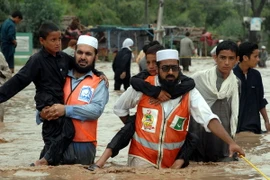 Nhân viên cứu hộ sơ tán người dân khỏi khu vực ngập lụt sau những trận mưa lớn tại Peshawar, Tây Bắc Pakistan ngày 26/7 vừa qua. (Ảnh: THX/TTXVN)