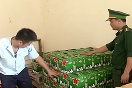 Lực lượng chức năng kiểm đếm số hàng lậu bắt giữ. (Ảnh minh họa: Hồ Cầu/TTXVN)