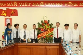 Ủy viên Bộ chính trị, Bí Thư Trung ương Đảng, Trưởng ban Tuyên giáo Trung ương Đinh Thế Huynh tặng lẵng hoa chúc mừng Thông tấn xã Việt Nam. (Ảnh: Minh Quyết/TTXVN)