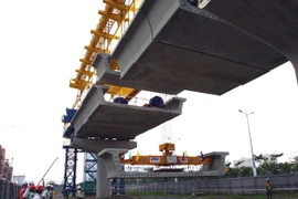 Hiện trường lắp đặt dầm cầu. (Ảnh: Hoàng Hải/TTXVN)