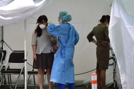 Nhân viên y tế kiểm tra thân nhiệt hành khách tại Bệnh viện Trường đại học Konkuk ở Seoul ngày 24/6. (Ảnh: AFP/TTXVN)