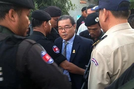 Cảnh sát Campuchia áp giải Thượng nghị sỹ Hong Sok Hour (giữa) tại Phnom Penh. (Ảnh: AFP/TTXVN)