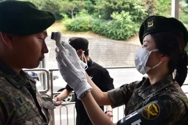 Kiểm tra thân nhiệt, một trong những biện pháp ngăn chặn sự lây lan của dịch bệnh MERS, tại lối vào Bộ Quốc phòng ở thủ đô Seoul ngày 9/6. (Ảnh: AFP/TTXVN)