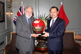 Phó Thủ tướng Vũ Văn Ninh trao tặng quà lưu niệm với Huân tước David Terence Puttnam. (Ảnh: Như Mai/TTXVN)