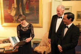 Đại sứ Việt Nam tại Australia Lương Thanh Nghị gặp Thống đốc bang Tasmania, giáo sư Kate Warner - người cầm xem cuốn sách ảnh. (Ảnh do Đại sứ quán Việt Nam tại Australia cung cấp)
