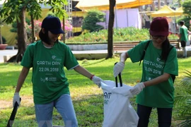 Tình nguyện viên tham gia nhặt rác thải trong Ngày Trái Đất năm 2018. (Ảnh Xuân Dự/TTXVN)