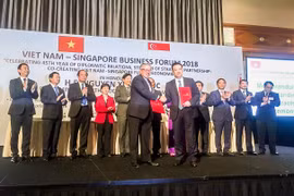 Đại diện Vietcombank, ông Phạm Quang Dũng, Tổng Giám đốc (hàng đầu, bên phải) và đại diện SBF, ông Ho Meng Kit – Giám đốc điều hành ký kết thỏa thuận hợp tác giữa hai bên. (Nguồn: Vietcombank)