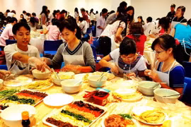 Các bạn học sinh, sinh viên Việt Nam tự mình làm các món ăn Hàn Quốc. (Ảnh: Thanh Hà/TTXVN)