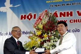 Ông Bùi Thanh Hà (phải) - Phó Ban Tôn giáo Chính phủ tặng hoa chúc mừng Mục sư Đinh Thiên Tứ, Giáo hội trưởng Hội thánh Liên hữu Cơ đốc Việt Nam tái đắc cử nhiệm kỳ 3. (Ảnh: Thế Anh/TTXVN)