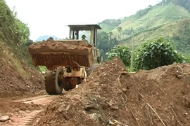 Ngành giao thông vận tải Quảng Nam xử lý sạt lở trên Quốc lộ 14E. (Ảnh: Đoàn Hữu Trung/TTXVN)