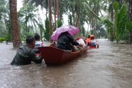 Lực lượng cứu hộ sơ tán người dân khỏi vùng ngập lụt sau những trận mưa lớn do ảnh hưởng của bão Trami tại tỉnh Albay, Philippines. (Ảnh: THX/TTXVN)